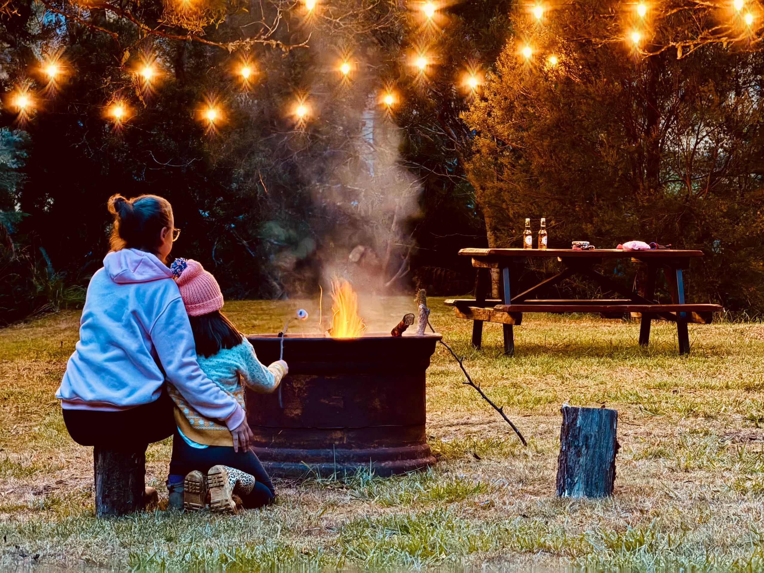 Family camping by a fire at night